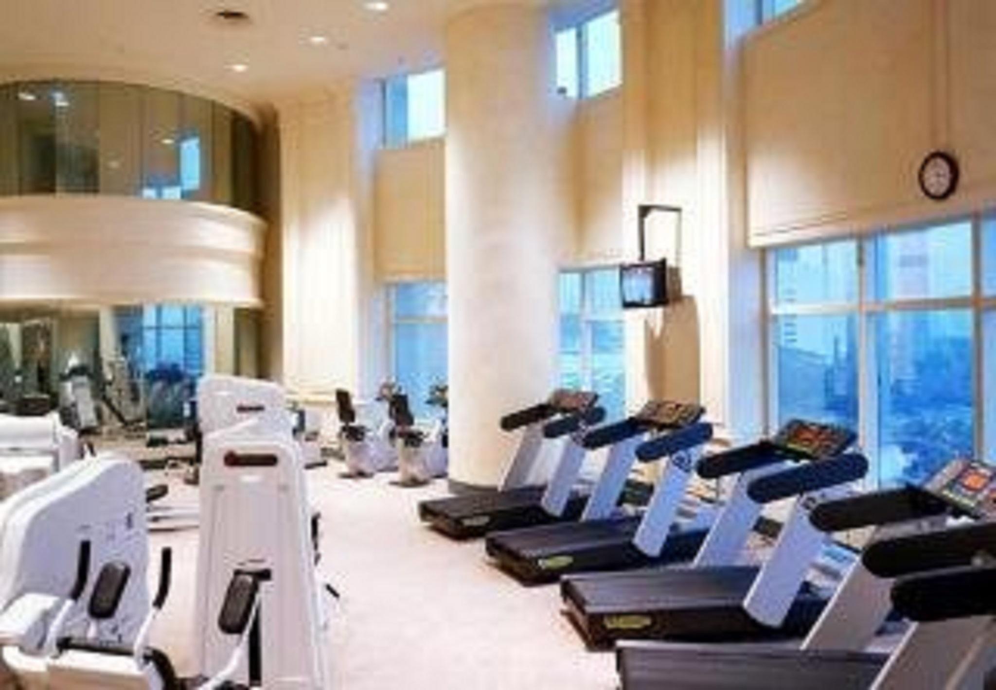 מלון Jw Marriott קואלה לומפור מתקנים תמונה The photo shows a modern gym or fitness center. It features rows of exercise machines, including treadmills and possibly stationary bikes. The interior has large windows that let in natural light, creating a bright and airy atmosphere. The walls are 