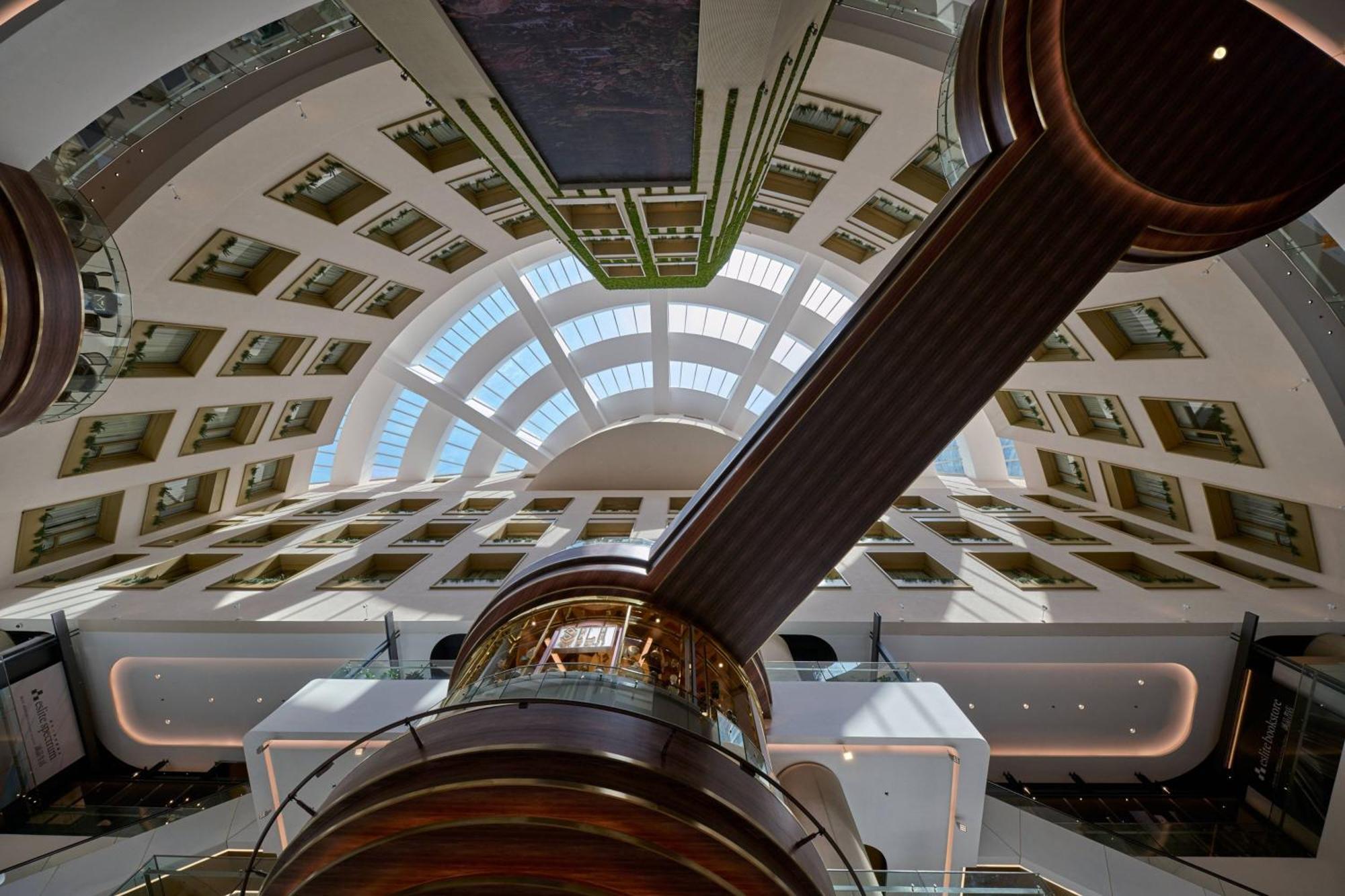 מלון Jw Marriott קואלה לומפור מראה חיצוני תמונה The image shows a modern architectural interior viewed from below, likely looking up at a large atrium or spacious lobby. The ceiling features a curved, segmented design with multiple skylights that allow natural light to flow in. There is a prominen