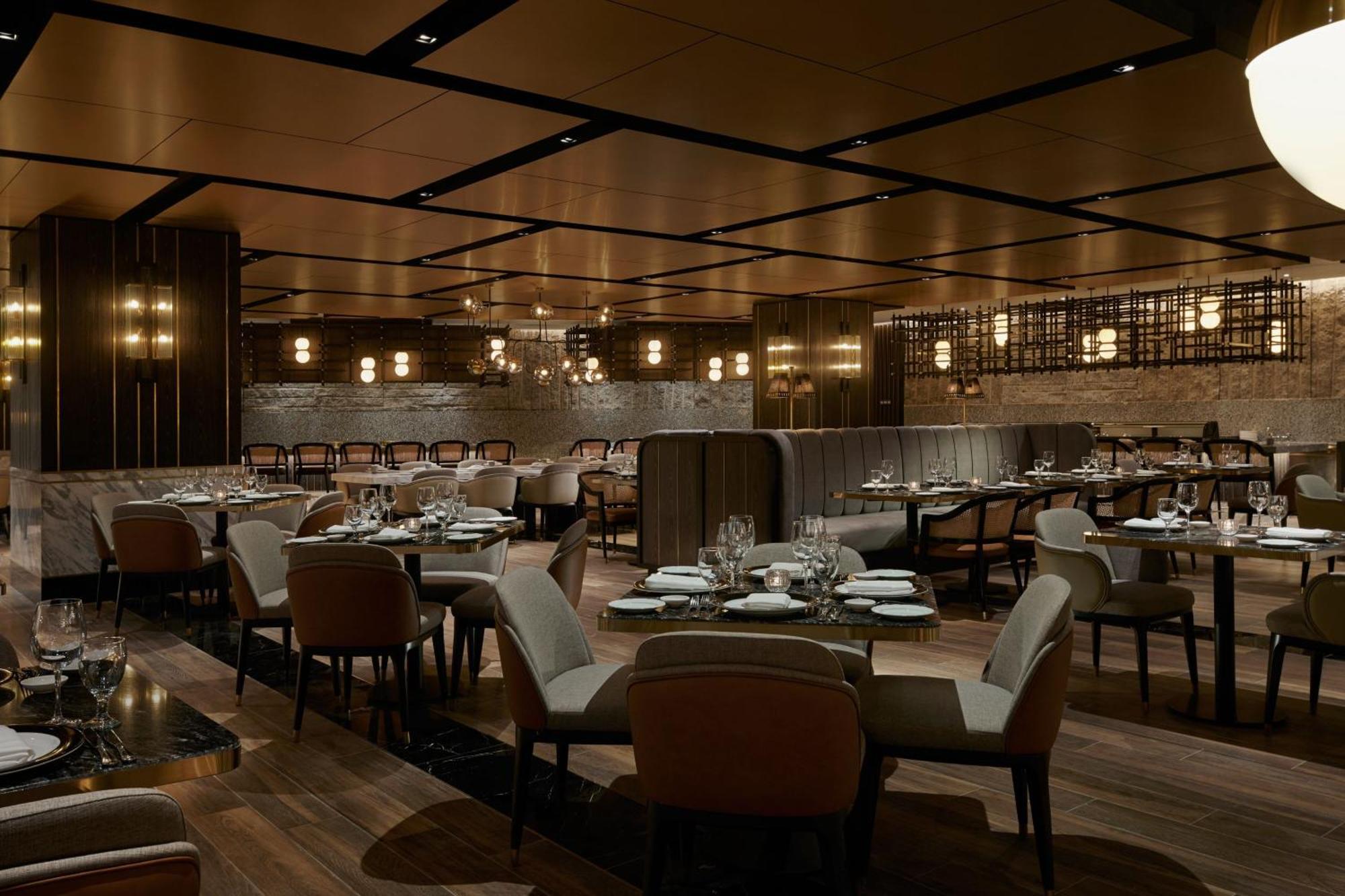 מלון Jw Marriott קואלה לומפור מראה חיצוני תמונה The photo depicts an elegant restaurant interior. It features a spacious layout with wooden flooring and a combination of dark and light decor. The seating consists of plush chairs arranged around tables, which are set with cutlery and plates. The ce